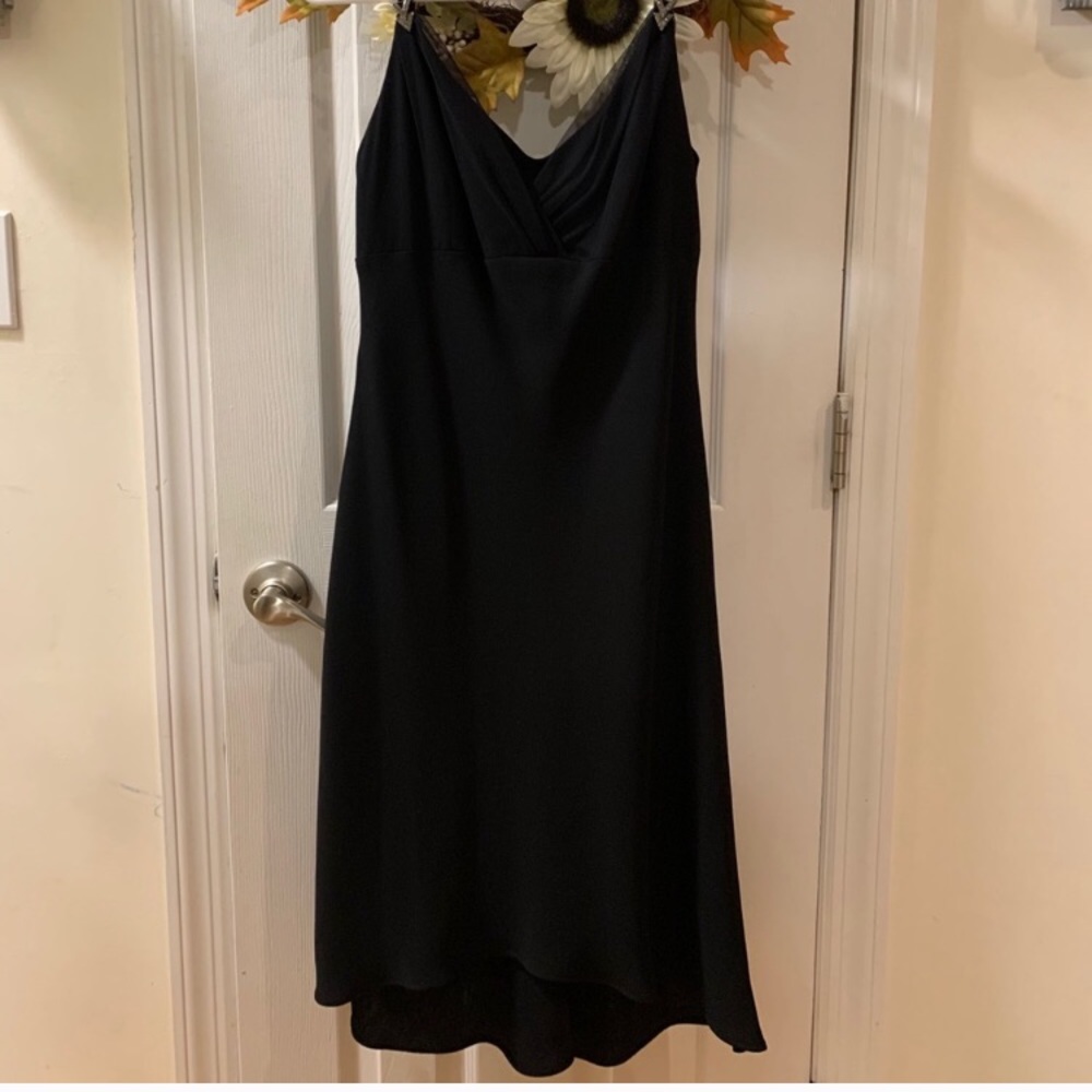 Black dress with two silver pens on the straps...